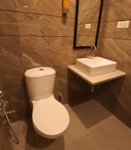 a bathroom with a white toilet and a sink at RoyalVilla in Chandīgarh