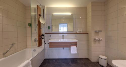a bathroom with a tub and a sink and a shower at Hotel Schwanen Stuttgart Airport/Messe in Filderstadt