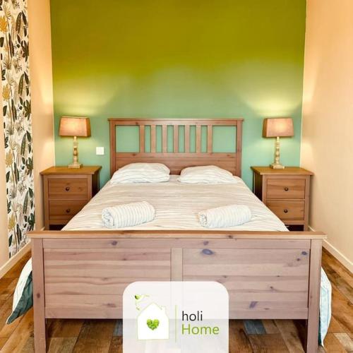 une chambre avec un grand lit avec deux tables de nuit dans l'établissement H9 Petite maison de campagne, à Domalain