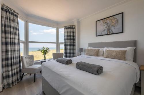 a bedroom with a large bed with a large window at Seaview at No.5 Mundesley in Mundesley