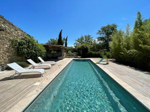 une piscine avec des chaises longues sur une terrasse en bois dans l'établissement La Malisse, à Vaison-la-Romaine
