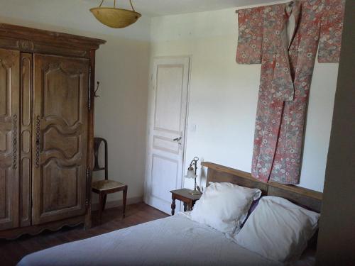 - une chambre dotée d'un lit avec une croix sur le mur dans l'établissement La Malisse, à Vaison-la-Romaine