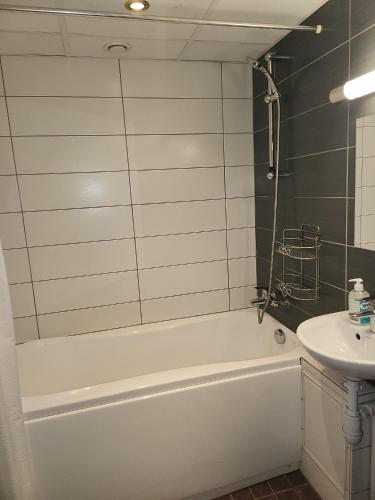 a bathroom with a white tub and a sink at Bright & Peaceful Room Near Old Town in Tallinn
