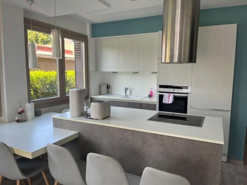 a kitchen with white cabinets and a counter with chairs at Le Balnéo in Thonon-les-Bains