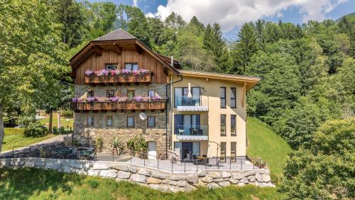 a house on a hill with flowers on a balcony at Turnerhof in Millstatt