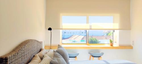 a living room with a couch and a window at IH Apartments & Studios in Espinho