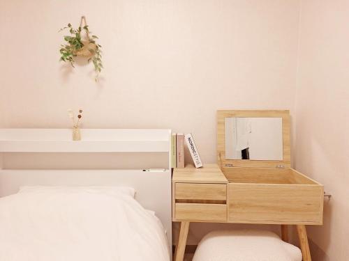 a bedroom with a bed and a dresser with a mirror at Hue stay 2 in Seoul