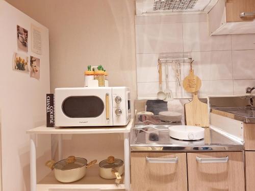 a microwave sitting on a shelf in a kitchen at Hue stay 2 in Seoul