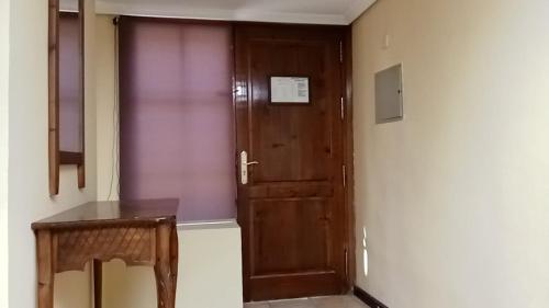 eine Holztür in einem Zimmer mit einem Tisch in der Unterkunft Apartamentos Jasmund - Bungalow 87 in San Fernando