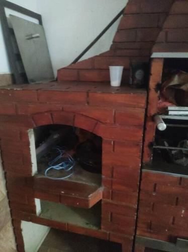 a brick fireplace in the middle of a room at Exclusivo Haras Marilu! in Atibaia