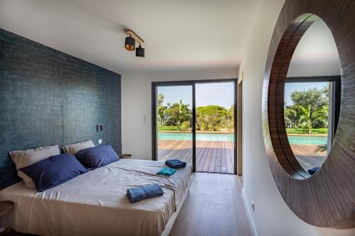 une chambre avec un grand lit et un miroir dans l'établissement Villa de la Madrague Vue Mer à 200m de la Plage sur La Presqu' île de Giens Sea and Mountain Pleasure, à Hyères