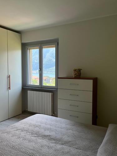 a bedroom with a bed and a dresser and a window at 2 Cuori al Lago - Appartamento in villetta singola in Mandello del Lario