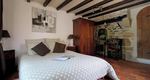a bedroom with a bed with a book on it at Le Domaine de la Vergnolle in Roches