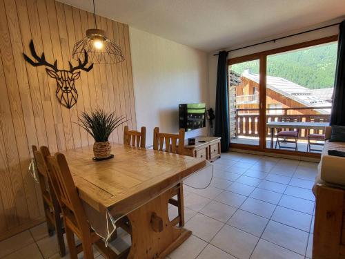 une salle à manger avec une table et des chaises en bois dans l'établissement Appartement skis aux pieds avec piscine, 4/5 personnes, Les Orres 1800 - FR-1-322-539, aux Orres