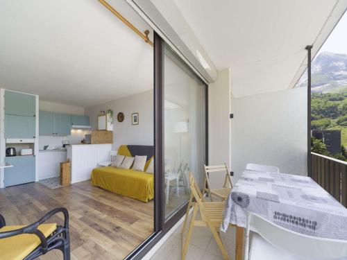 Cette chambre dispose d'un balcon avec un lit et d'une cuisine. dans l'établissement Appartement Lumineux 4 Pers à 200m des Pistes - Balcon et Casier à Skis - FR-1-400-130, à Eaux-Bonnes