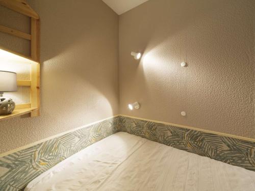 - un coin de chambre avec un lit dans l'établissement Appartement Lumineux 4 Pers à 200m des Pistes - Balcon et Casier à Skis - FR-1-400-130, à Eaux-Bonnes