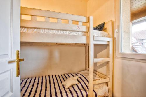 une chambre avec deux lits superposés et une fenêtre dans l'établissement Petit Golf résidence privée piscine chauffée, à Deauville