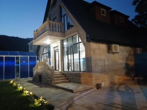 a house with a staircase in front of it at Viva hotel Gabala with outdoor pool ,Sauna and Waterfall in Gabala