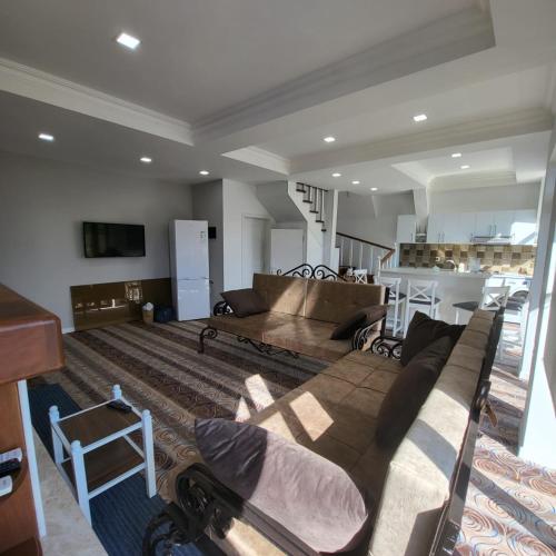a living room with a couch and a kitchen at Viva hotel Gabala with outdoor pool ,Sauna and Waterfall in Gabala