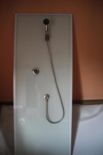 una doccia con tubo su una parete bianca di SALAMANDRES a Tergnier