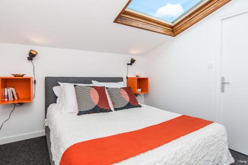 - une chambre dotée d'un lit avec une couverture orange et blanche dans l'établissement Pomme d'Eve - Hypercentre - Clim, à Toulouse