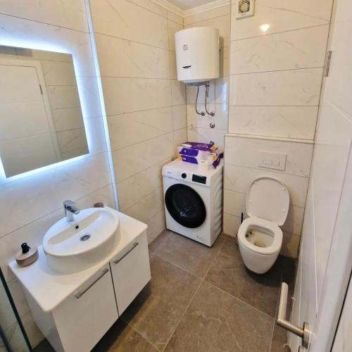 a bathroom with a sink and a washing machine at Apartman BOSS Lux in Trebinje