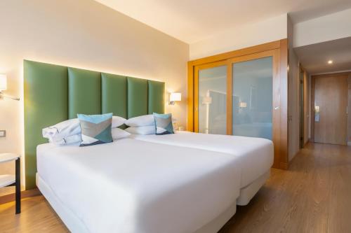 Кровать или кровати в номере Hesperia Barcelona Sant Just
