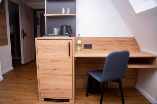 a desk with a blue chair in a room at Hotel Restaurant Wolfsschlucht GmbH in Bad Münstereifel