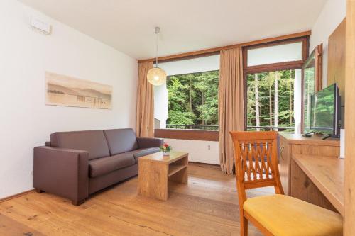 a living room with a couch and a chair at Appartementhaus Dachsteinblick mit Indoorpool und Sauna in Bad Goisern