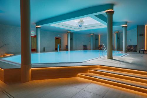 a swimming pool in a building with a blue light at Haus Elim für Gruppen und Großfamilien in Heringsdorf