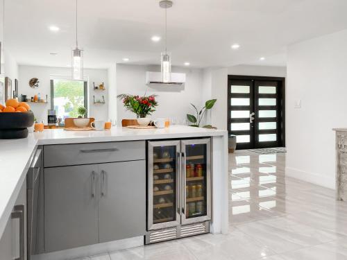 a kitchen with a white counter top with a refrigerator at Villa Palma - Prime Location, Pool, Game Room, Outdoor Kitchen in Miami