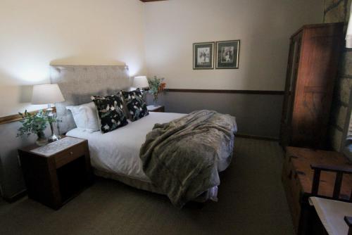 a bedroom with a bed and a table and lamps at Moolmanshoek Private Game Reserve in Fouriesburg