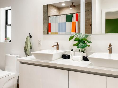 a white bathroom with two sinks and a mirror at Villa Palma - Prime Location, Pool, Game Room, Outdoor Kitchen in Miami