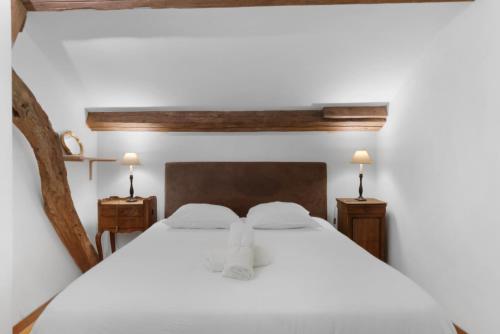 una camera da letto con un grande letto bianco con due lampade di Cottages Normands (deux maisons) a Houlgate