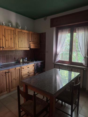 a kitchen with wooden cabinets and a table with chairs at B&B Snow Village Roccaraso in Roccaraso