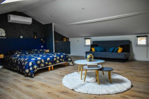 une chambre avec un lit, une table et un canapé dans l'établissement Chez Dyl's Villa tout confort, à Saint-Georges-du-Bois