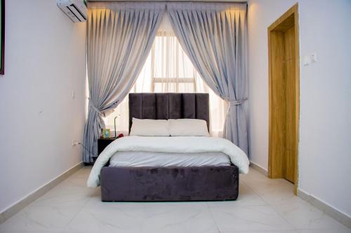 a bedroom with a large bed in front of a window at 3 Bed Room Villa, Serenity in the Heart of Lekki in Sangotedo