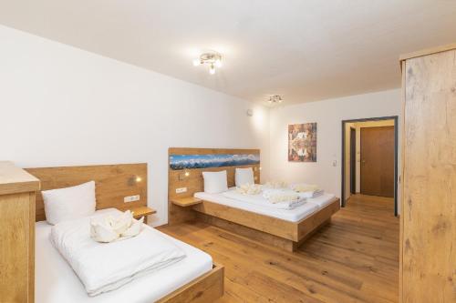two beds in a room with wooden floors at Appartementhaus Dachsteinblick mit Indoorpool und Sauna in Bad Goisern