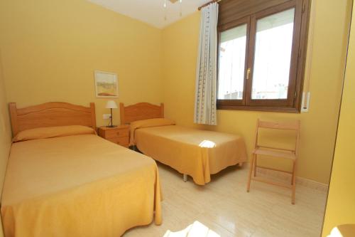 ミアミ・プラトーヤにあるARENDA Pino Alto Holiday Home Masia 2のベッドルーム1室(ベッド2台、窓、椅子付)