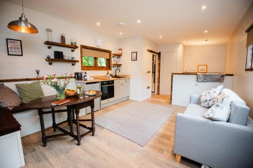 a kitchen and living room with a table and a couch at A Place In the Pennines in Huddersfield