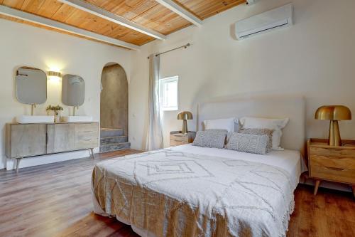 - une chambre avec un grand lit et deux miroirs sur le mur dans l'établissement A Casetta - Maison climatisée avec piscine, à Belgodère
