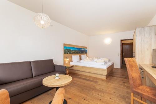a living room with a couch and a bed at Appartementhaus Dachsteinblick mit Indoorpool und Sauna in Bad Goisern