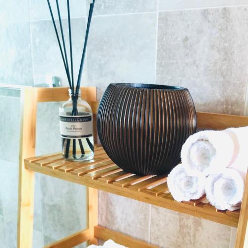 a black vase sitting on a shelf with towels at Colina Smir Resort Marina Smir, Tamuda Bay Kabila Beach, M'diq in Sania Torres