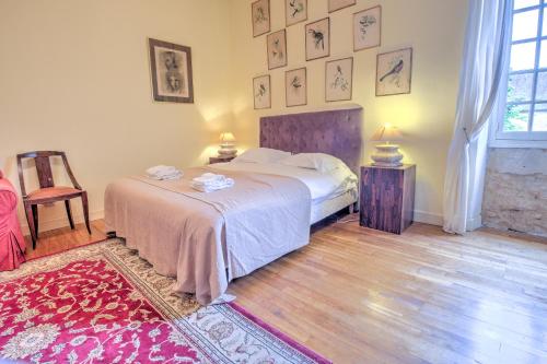 a bedroom with a large bed and a rug at Le Bel Prat in Domme