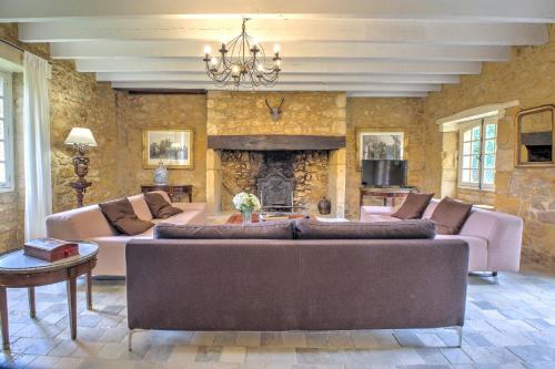 a large living room with couches and a fireplace at Le Bel Prat in Domme