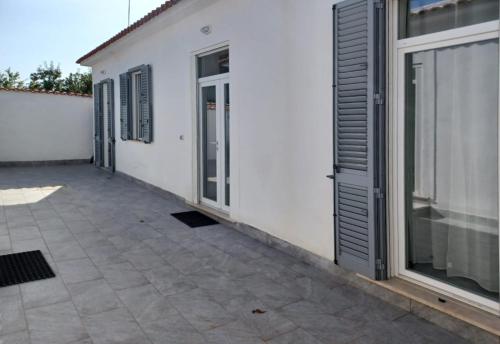 een wit gebouw met een deur en een patio bij Holiday Homes Villetta Blu in Nettuno