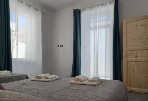 a bedroom with two beds with towels on them at Holiday Homes Villetta Blu in Nettuno