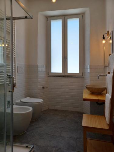 a bathroom with two sinks and a toilet and a window at Holiday Homes Villetta Blu in Nettuno