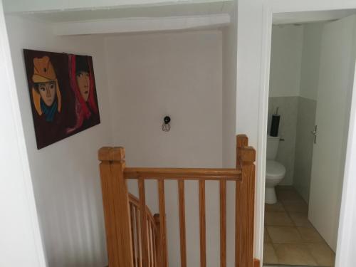 un couloir avec un escalier et une peinture murale dans l'établissement Le moulin mallat mazeyrat d allier 43300, à Mazeyrat-d'Allier