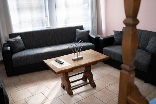 a living room with two couches and a coffee table at Hotel Restaurant Wolfsschlucht GmbH in Bad Münstereifel